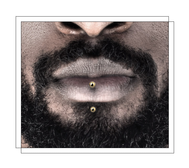 Located just above the chin and centered below the bottom lip. It is not attached to the lip itself. Also known as a vertical labret, which places a curved barbell centered on the bottom lip - one end through the lip, and the other where a traditional labret would be placed. Perhaps the most unique aspect of the vertical labret piercing is that it never touches the inside of the mouth.